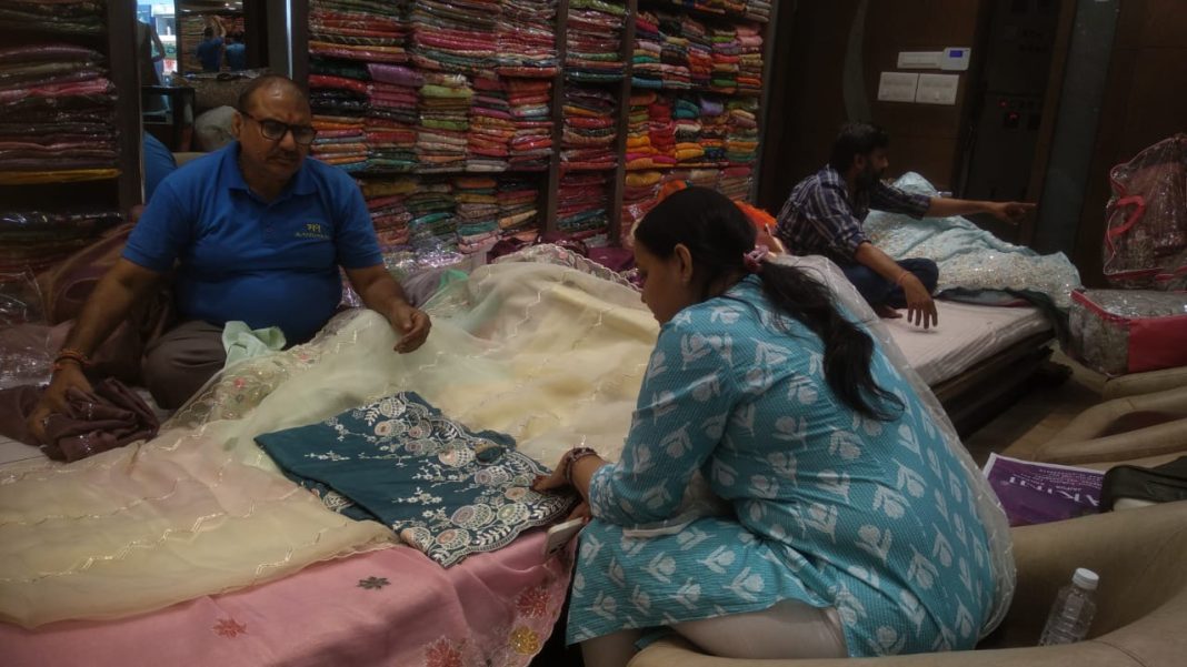 जयपुर के मंदाकनी साडीज़ शोरूम में महिला ग्राहक खूबसूरत साड़ियों का चयन करती हुईं।